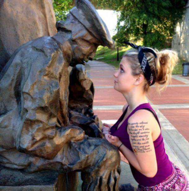 девушка показывает грудь памятнику