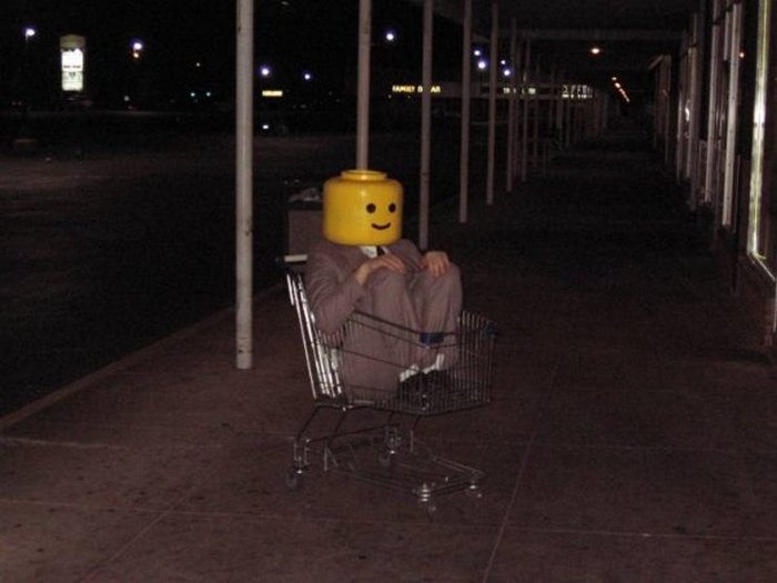 парень сидит в тележке из супермаркета