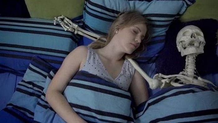 девушка в постели со скелетом