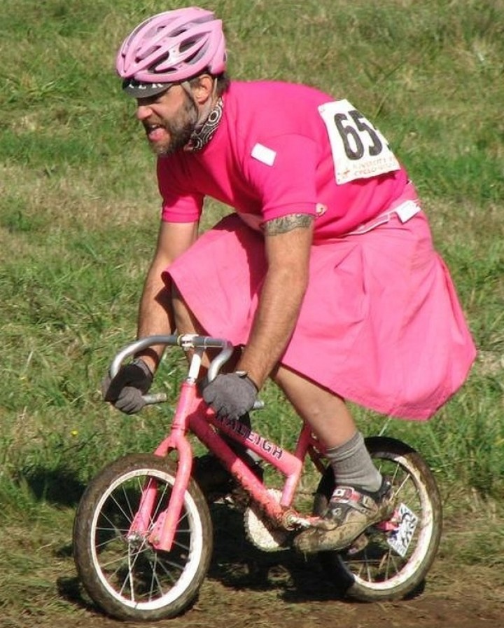 мужчина в розовом на детском велосипеде