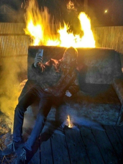 мужчина делает селфи на горящем диване