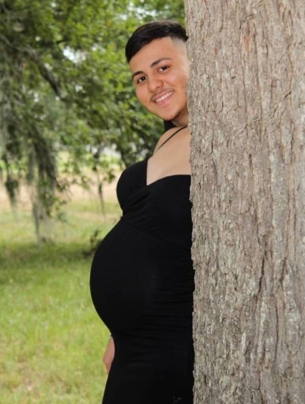 беременная женщина и парень за деревом