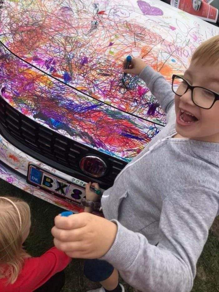 ребенок разрисовывает машину
