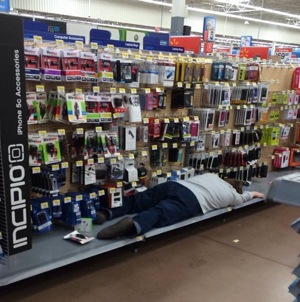 мужчина спит на полке в супермаркете