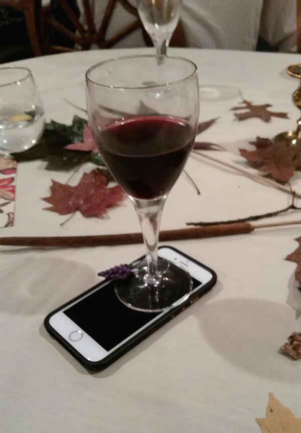 бокал с вином стоит на телефоне