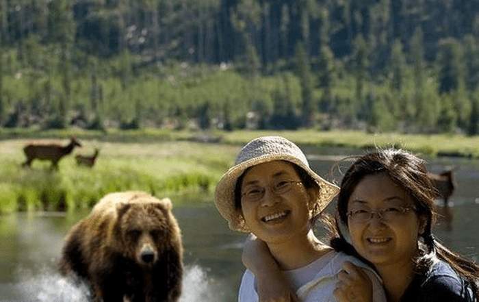 китаянки позируют на фоне медведя