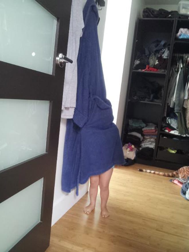 ребенок прячется под халатом