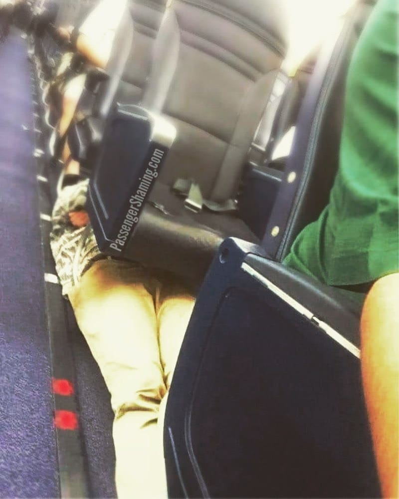 мужчина лежит под креслами в самолете