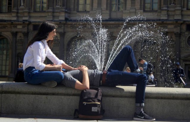 парень и девушка сидят у фонтана
