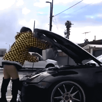 девушка льет масло под капот авто
