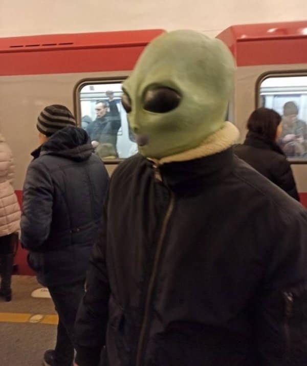 парень в маске пришельца в метро