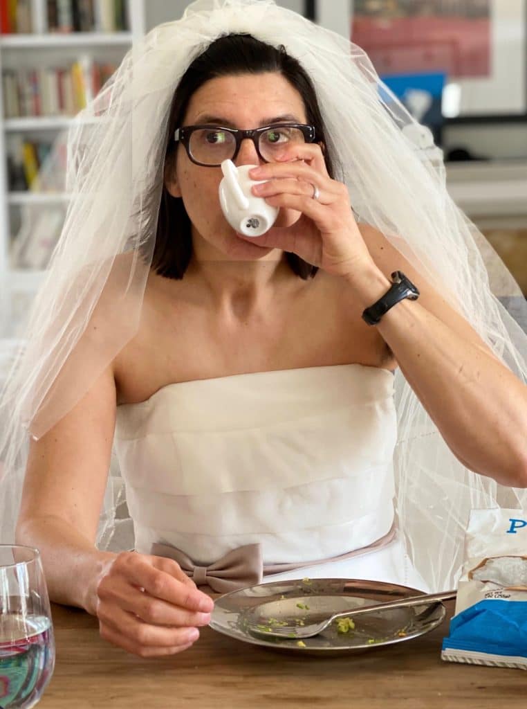 женщина в свадебном платье пьет из чашки