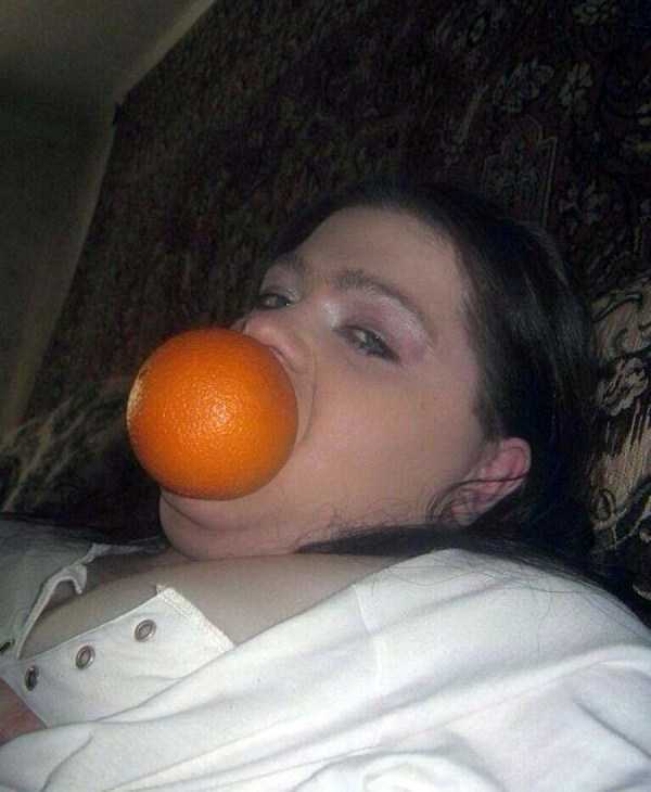 девушка с апельсином во рту