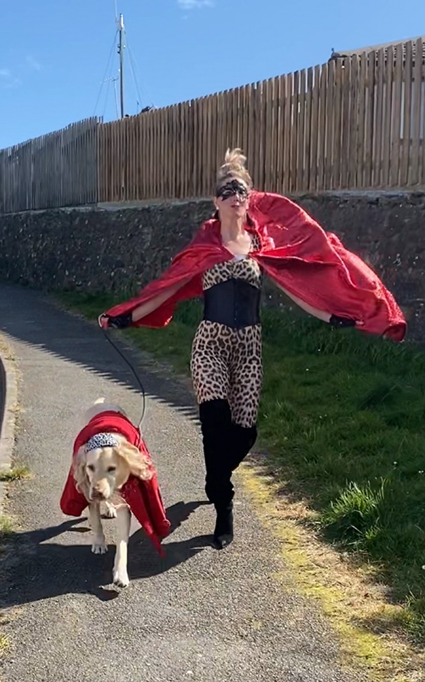 женщина в костюме супергероя с собакой