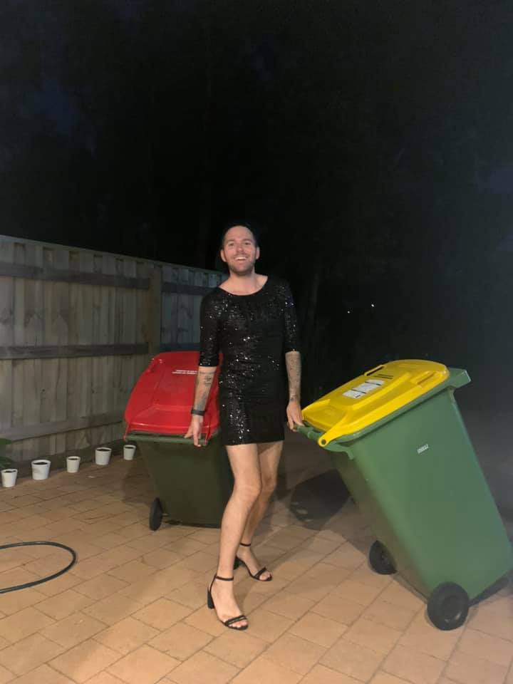 мужчина в платье и на каблуках выносит мусор