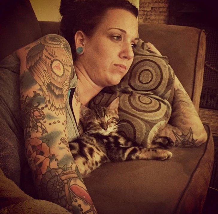 девушка лежит на диване с котенком