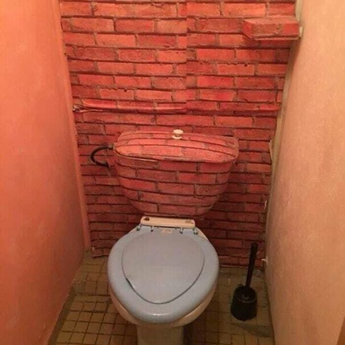 кирпичная стена и бачок в туалете