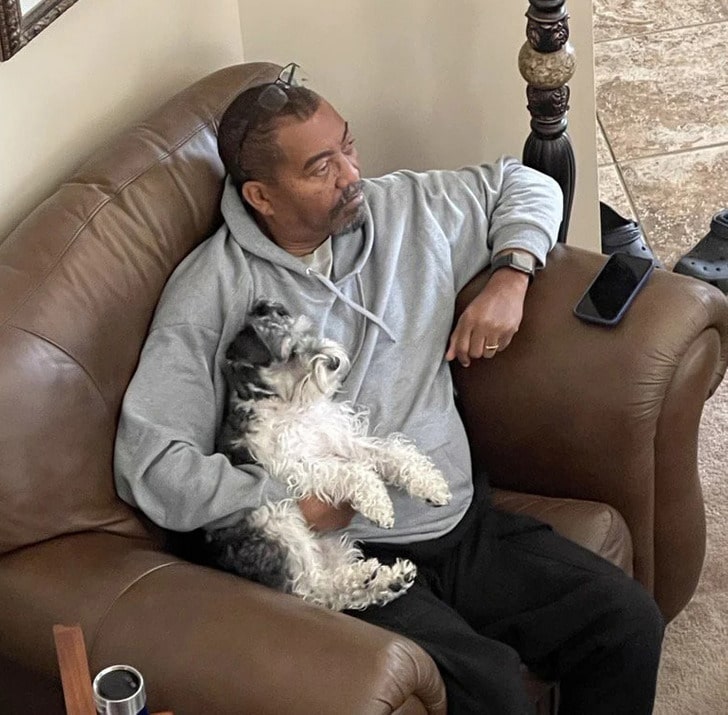 мужчина с собакой сидит в кресле