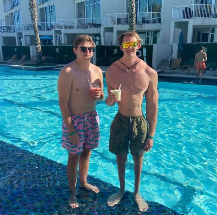 два парня стоят возле бассейна