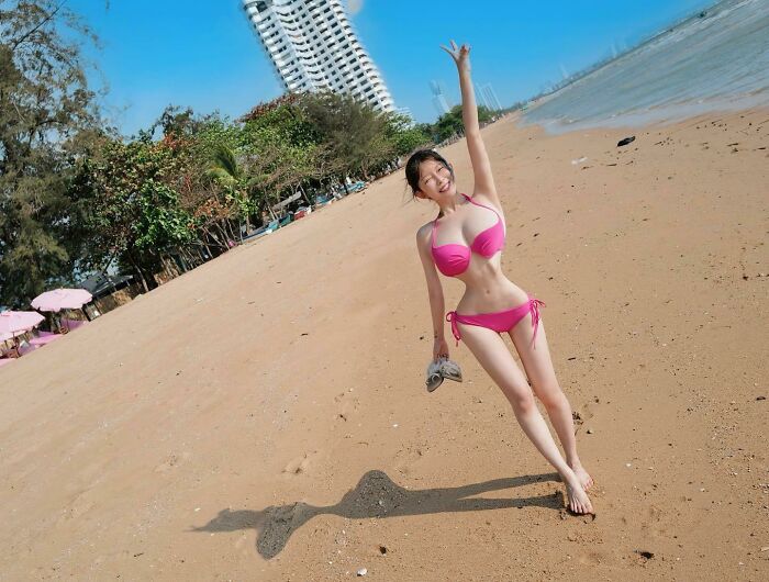 девушка в розовом купальнике на пляже