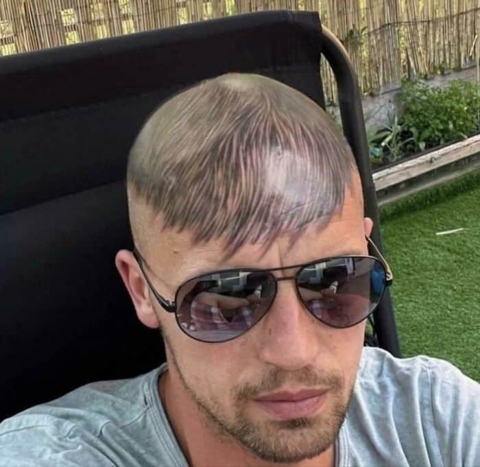 мужчина в очках с татуировкой волос на голове