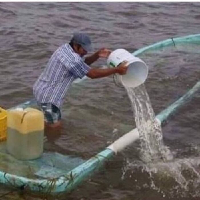 мужчина вычерпывает воду из тонущей лодки